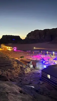 a view of a beach at night with pink lights at Rotana Wadi Rum in Wadi Rum
