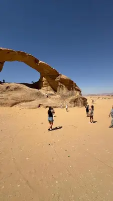 a group of people standing on a beach at Rotana Wadi Rum in Wadi Rum