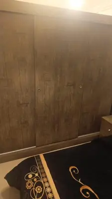 a bedroom with a brown wall and a black rug at lNTERCoNTlNENTALAL in Amman