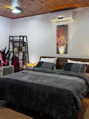 a bedroom with a large bed with a painting on the wall at Cozy and well-located 2 bedroom flat near a mall in Amman
