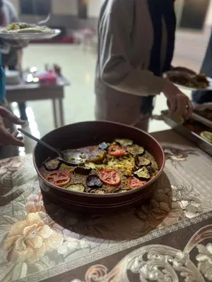 a person preparing a dish of food in a pan on a table at DESERT BREATHS lUXURY CAMP in Wadi Rum