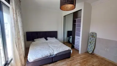 a bedroom with a bed and a large window at Nice cozy place in Amman