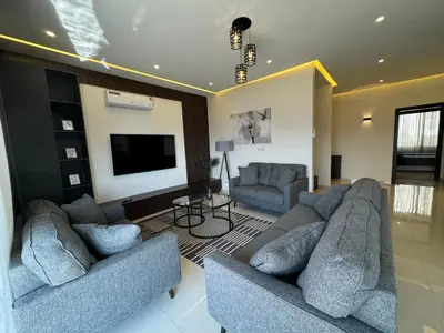 a living room with two couches and a flat screen tv at The view in Māḩiş