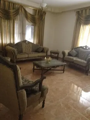 a living room with couches and a coffee table at Furnished apartment for rent in Amman