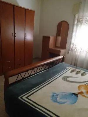 a bedroom with a bed and a dresser at Furnished apartment for rent in Amman