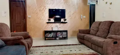 a living room with two couches and a tv at شقة كبيرة مميزة للعائلات -مدخل مستقل in Amman
