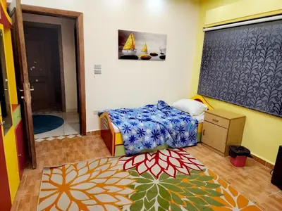 a small bedroom with a bed and a chalkboard at شقة كبيرة مميزة للعائلات -مدخل مستقل in Amman