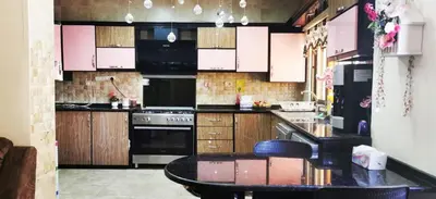 a kitchen with a stove and a table in it at شقة كبيرة مميزة للعائلات -مدخل مستقل in Amman