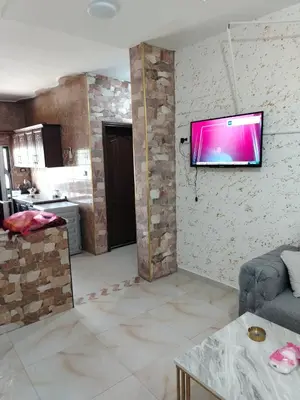 a living room with a tv hanging on a wall at الشقة الفاخرة الحديثة in Amman