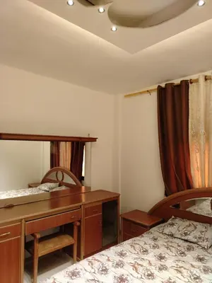 a bedroom with two beds and a desk and a mirror at الشقة الفاخرة الحديثة in Amman