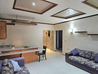 a living room with a couch and a kitchen at Red Sea Pearl Luxury Villa in Aqaba in Aqaba