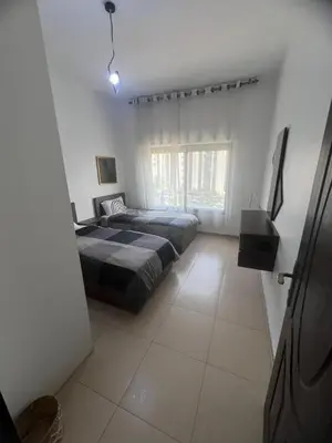 a bedroom with two beds and a window at عبدون الشمالي in Amman