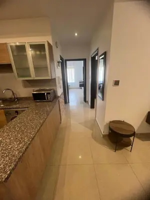 a kitchen with a counter top and a table at عبدون الشمالي in Amman