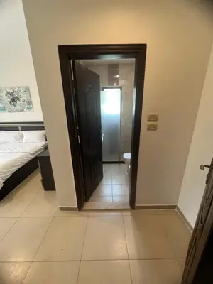 a hallway with a door leading to a bedroom at عبدون الشمالي in Amman