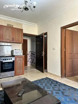 a kitchen with a stove and a table in a room at studio al jubiha 1 استوديو الجبيهة in Amman