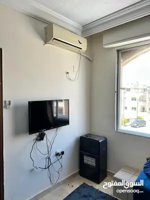a room with a flat screen tv on a wall at studio al jubiha 1 استوديو الجبيهة in Amman