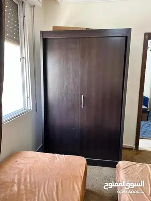 a large wooden door in a room with a bed at studio al jubiha 1 استوديو الجبيهة in Amman