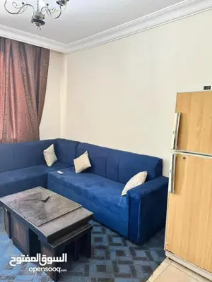 a blue couch in a living room with a table at studio al jubiha 1 استوديو الجبيهة in Amman