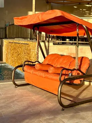 an orange bed with an umbrella on top of it at sama vailla in Amman