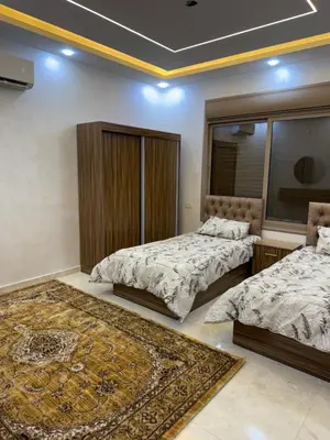 a bedroom with two beds and a rug at شالية جوهرة جراسيا Jewel of Gracia Chalet in Jerash
