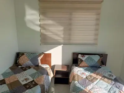 a bedroom with two beds and a window at شاليه ومزرعة طبقة فحل Chalet Pella