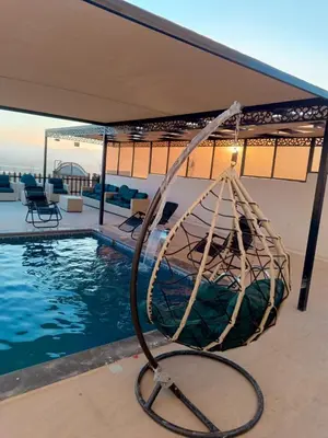 a swimming pool with a metal swing next to a swimming pool at شاليه ومزرعة طبقة فحل Chalet Pella