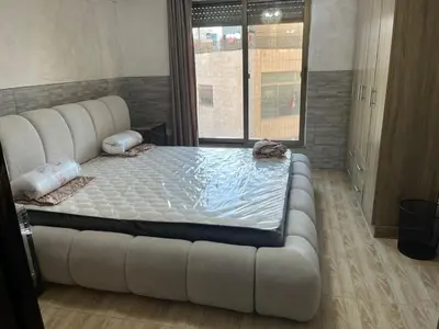 a large white bed in a room with a couch at Central affordable studio in Amman