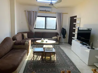 a living room with a couch and a table and a tv at Affordable Furnished 2BR for Rent in Amman