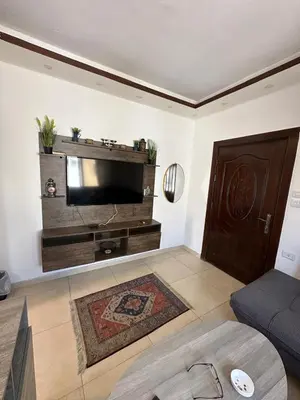 a living room with a tv and a couch at MK5 - One bedroom Apartment in Amman