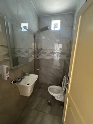 a bathroom with a sink and a toilet and a shower at شاليه هاف مليون الرامة in Al Mazār