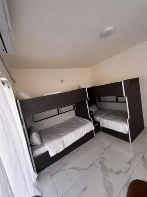 two bunk beds in a room with a tile floor at شاليه هاف مليون الرامة in Al Mazār