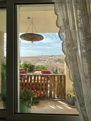 a window with a view of a balcony with plants at B&B petrafarmhouse in Wadi Musa