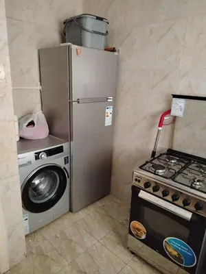a kitchen with a stove and a refrigerator and a washing machine at العقبة in Aqaba