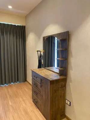 a room with a wooden dresser with a mirror at Luxury one bedroom in DAMAC in Amman