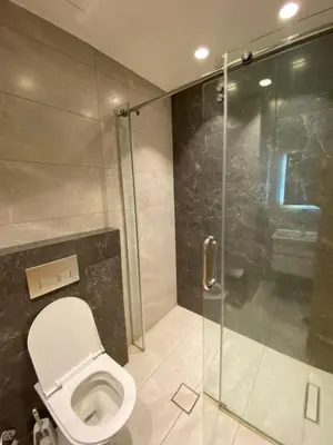 a bathroom with a toilet and a glass shower at Luxury one bedroom in DAMAC in Amman