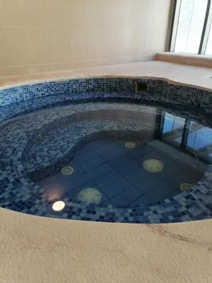 a swimming pool with a tile floor in a house at Luxury one bedroom in DAMAC in Amman