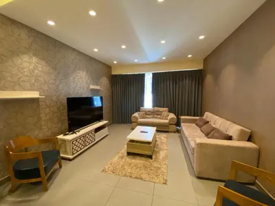 a living room with two couches and a tv at Luxury one bedroom in DAMAC in Amman