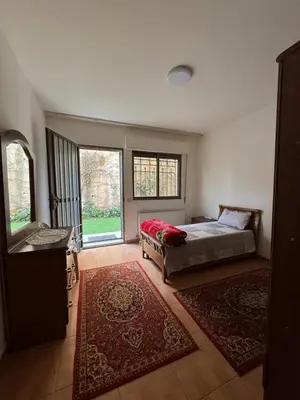 a bedroom with a bed and a large window at Comfort Apartment in Amman