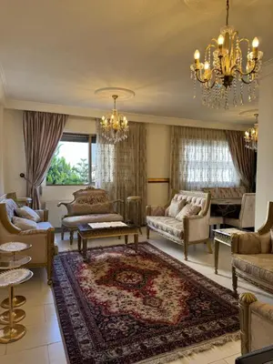 a living room with furniture and a chandelier at Comfort Apartment in Amman