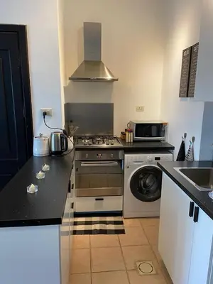 a kitchen with a stove and a washing machine at Studio for Rent in Jabal Alweibdeh-Amman - Jordan in Amman