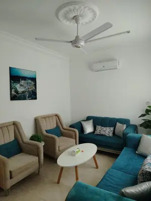 a living room with blue couches and a table at العقبه in Aqaba