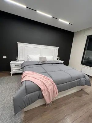 a bedroom with a large bed with a white headboard at Amman Central Comfort in Amman