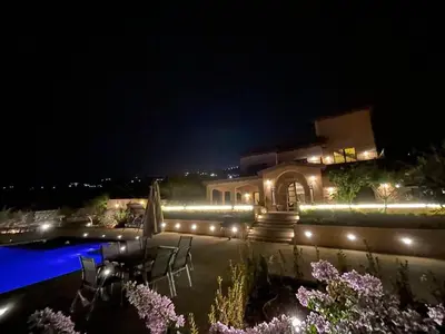 a house with a swimming pool at night with lights at sofia Farm in Al Salt