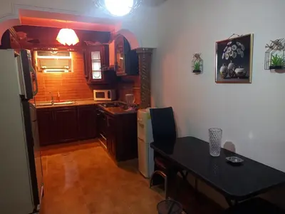a kitchen with a table and a refrigerator and a sink at Luxury furnished apartment for rent - شقة فاخرة مفروشة للإيجار in Amman