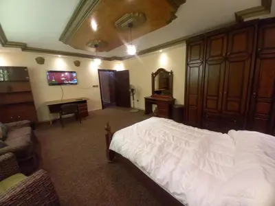 a bedroom with a bed and a couch and a tv at Luxury furnished apartment for rent - شقة فاخرة مفروشة للإيجار in Amman