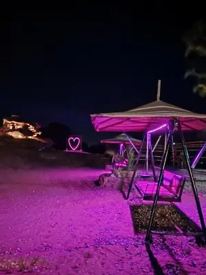a picnic table with purple lights in the dark at مخيم علاء in Wadi Rum