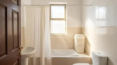 a bathroom with a tub and a toilet and a sink at Cozy & Spacious 3 En-Suite Bedroom Apartment in Amman