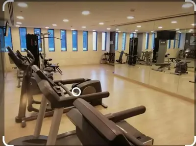 a gym with treadmills and ellipticals in a building at Sunny Duplex for rent in Abdali in Amman