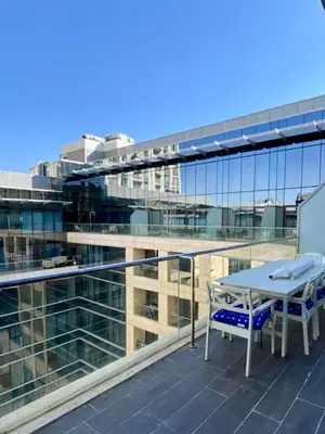 a balcony with a table and chairs on a building at Sunny Duplex for rent in Abdali in Amman
