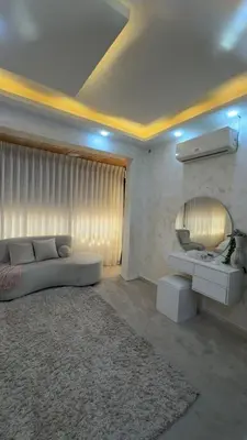 a living room with a bed and a mirror at شقق-روف للايجار اليومي والاسبوعي in Al Qarţū‘īyah